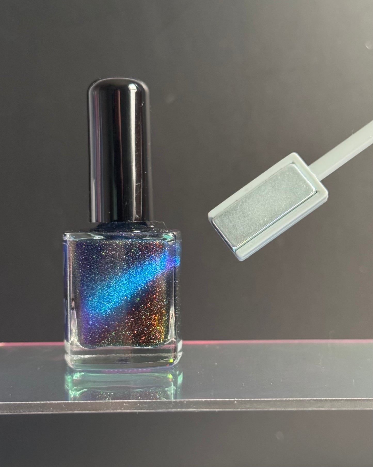 Rectangle end of magnetic wand pulls magnetic pigments into a line.